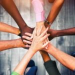 Close up view of young business people putting their hands together. Stack of hands. Unity and teamwork concept.