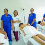 Facilitadora y participantes del INFOTEP en taller de masajes